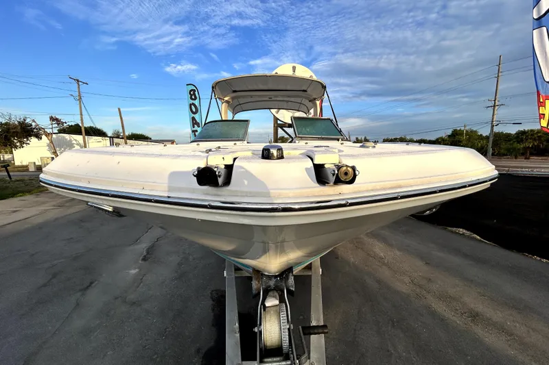 Slide: The Image of 2021 Regal 26 FasDeck boat on trailer, viewed from the front, under a blue sky. - 9