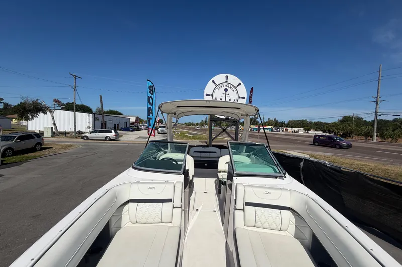 Slide: The Image of 2021 Regal 26 FasDeck boat with white interior, parked outdoors under clear blue sky. - 51