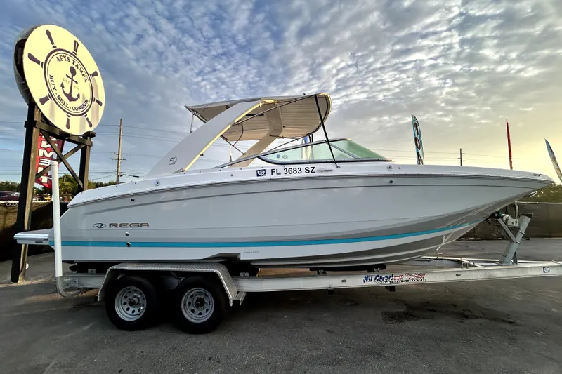 Slide: The Image of 2021 Regal 26 FasDeck boat on trailer under a cloudy sky. - 1