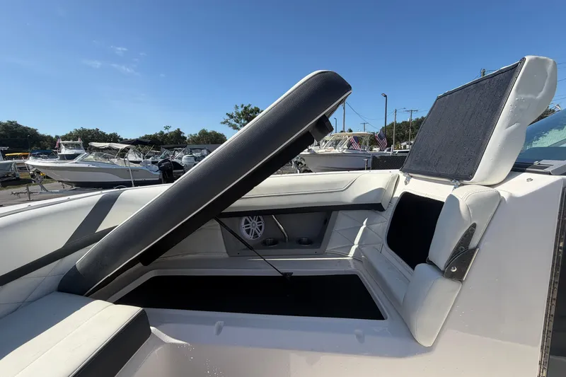 Slide: The Image of 2021 Regal 26 FasDeck boat interior with adjustable seating and speaker, docked under clear sky. - 56