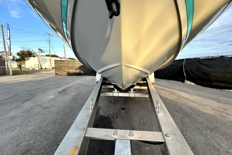 Slide: The Image of 2021 Regal 26 FasDeck boat on trailer, viewed from the front, outdoors. - 12