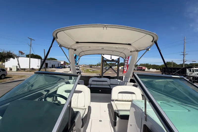 Slide: The Image of 2021 Regal 26 FasDeck boat with open cockpit and seating, parked outdoors. - 60
