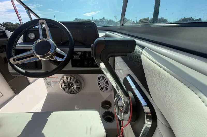 Slide: The Image of 2021 Regal 26 FasDeck boat cockpit with steering wheel and throttle controls. - 35