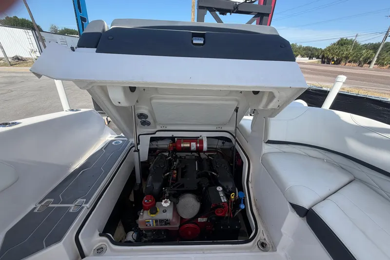 Slide: The Image of 2021 Regal 26 FasDeck boat engine compartment with open hatch, showcasing engine details. - 75