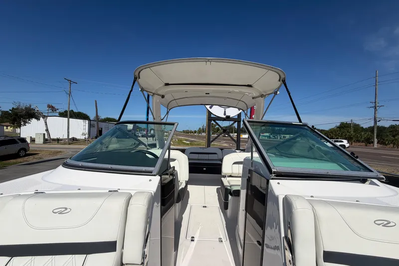 Slide: The Image of 2021 Regal 26 FasDeck boat with open cockpit and seating, parked outdoors. - 52