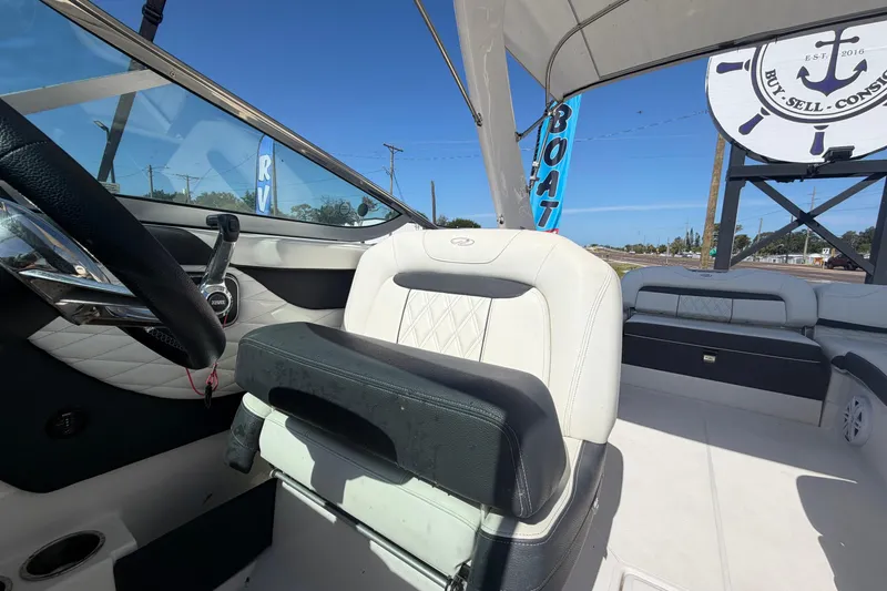 Slide: The Image of Interior of a 2021 Regal 26 FasDeck boat with steering wheel and seating. - 63
