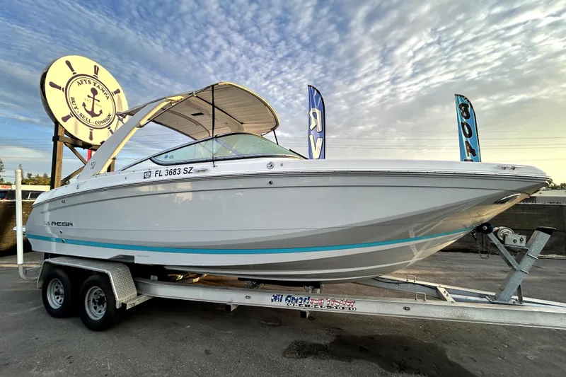 The Image of 2021 Regal 26 FasDeck boat on trailer under a cloudy sky. - 0