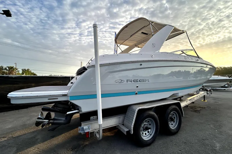 Slide: The Image of 2021 Regal 26 FasDeck boat on trailer under cloudy sky. - 2