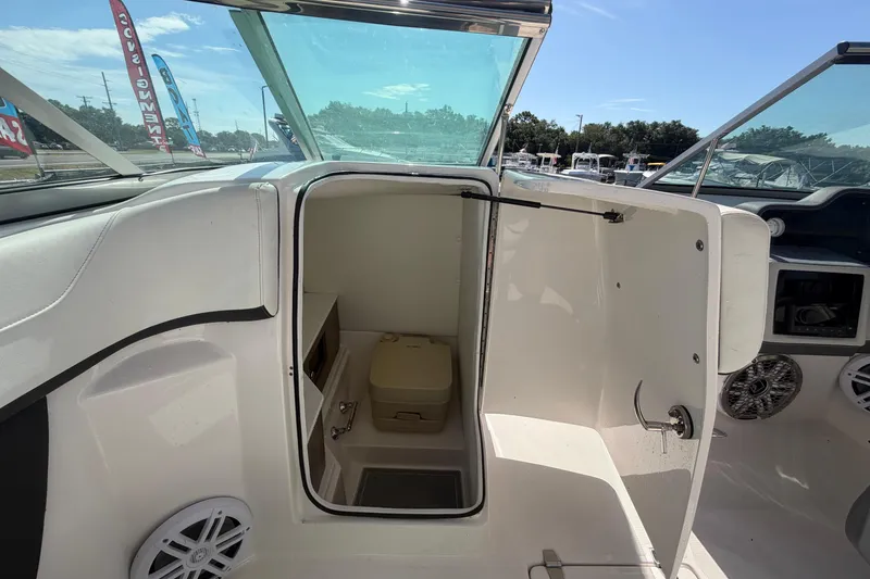 Slide: The Image of 2021 Regal 26 FasDeck boat interior with open cabin door and seating area. - 42