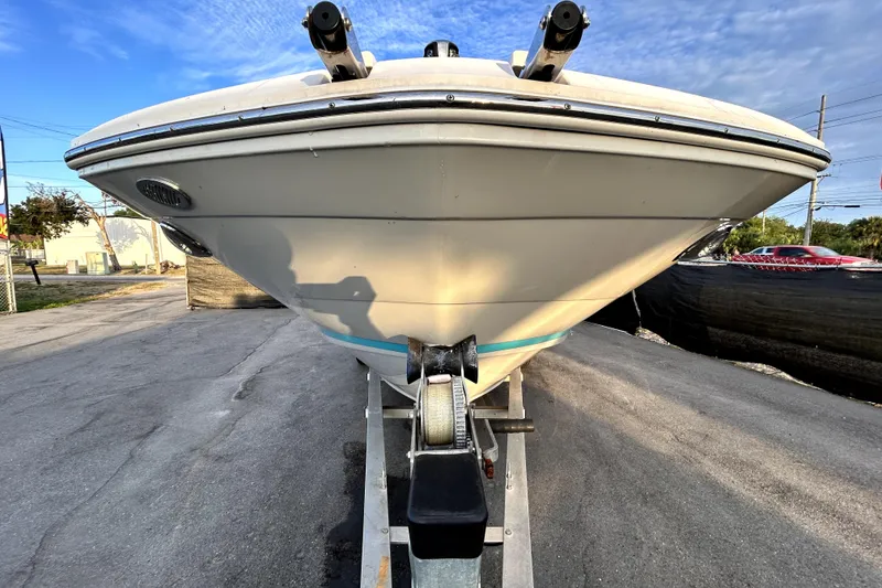Slide: The Image of 2021 Regal 26 FasDeck boat on trailer, front view under clear sky. - 10