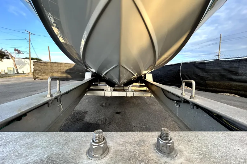Slide: The Image of 2021 Regal 26 FasDeck boat on trailer, viewed from below, showcasing hull design. - 11