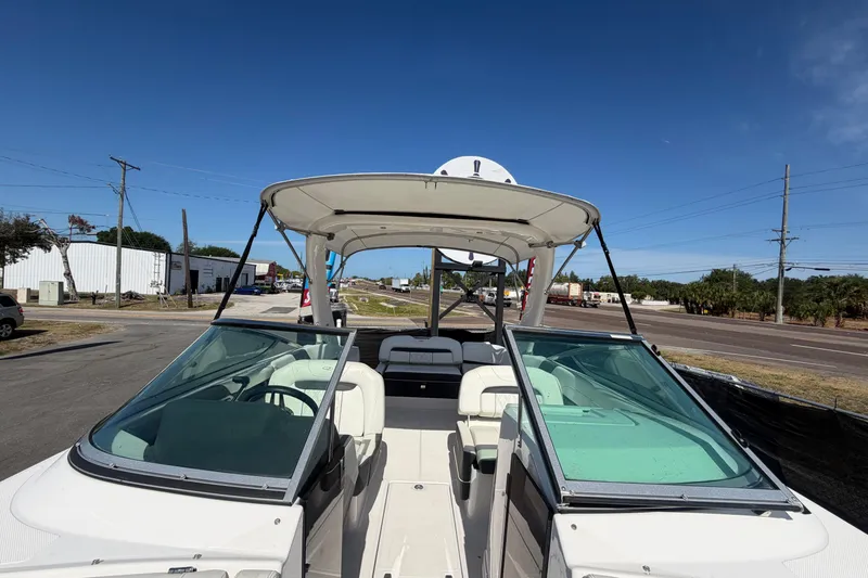 Slide: The Image of 2021 Regal 26 FasDeck boat with canopy, parked on a sunny day. - 59