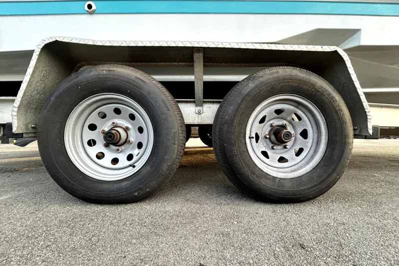 Slide: The Image of Trailer wheels of a 2021 Regal 26 FasDeck boat on pavement. - 84