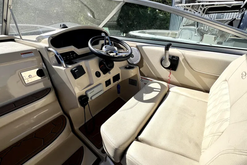 Slide: The Image of 2021 Regal 26 XO boat interior with steering wheel and beige seating. - 28
