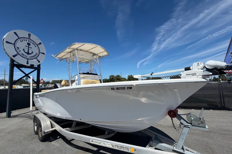 The Image of 2021 Sportsman Heritage 211 Center Console boat on trailer under clear blue sky. - 0