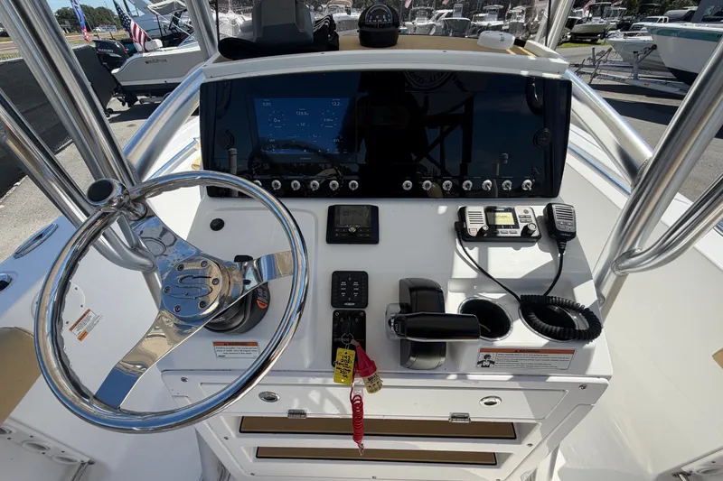 Slide: The Image of 2021 Sportsman Heritage 211 Center Console boat dashboard with steering wheel and controls. - 21