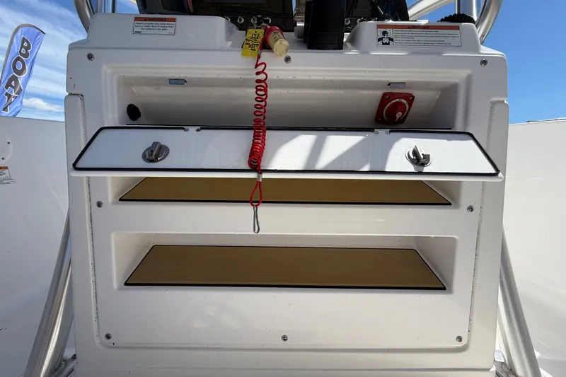Slide: The Image of 2021 Sportsman Heritage 211 Center Console storage compartments with safety features and controls. - 30