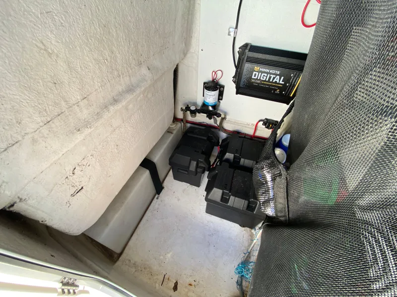 Slide: The Image of 2021 Sportsman Heritage 211 Center Console battery compartment with digital charger and wiring. - 17