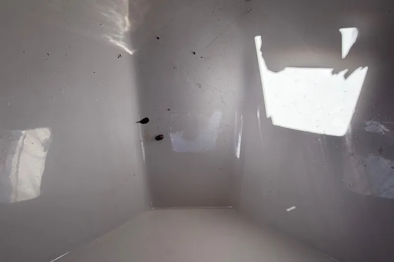 Slide: The Image of Interior view of an empty, white boat storage compartment with some stains. - 45