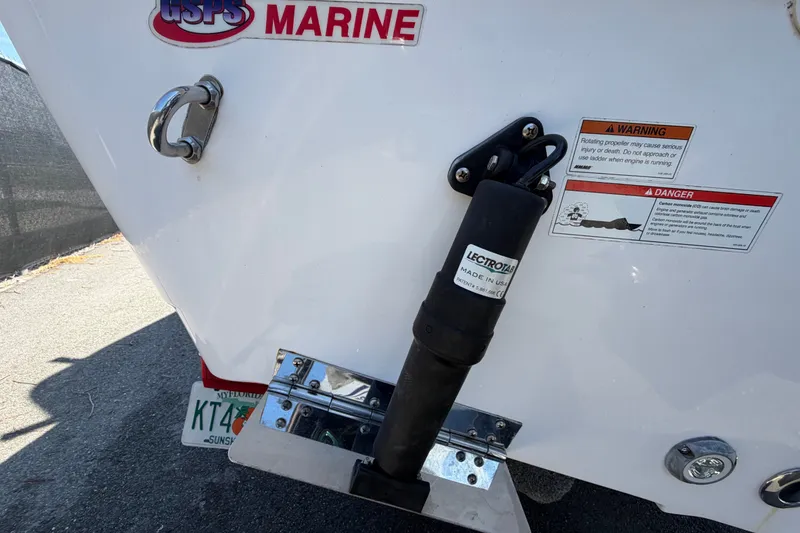 Slide: The Image of 2021 Sportsman Heritage 211 Center Console boat stern with warning labels and trim tab. - 6