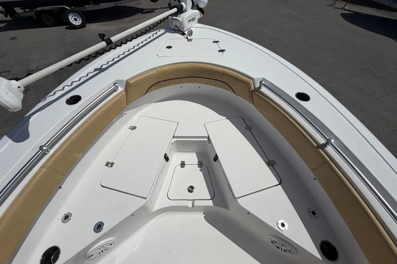 Slide: The Image of The image shows the bow of a 2021 Sportsman Heritage 211 Center Console boat with seating and storage. - 39