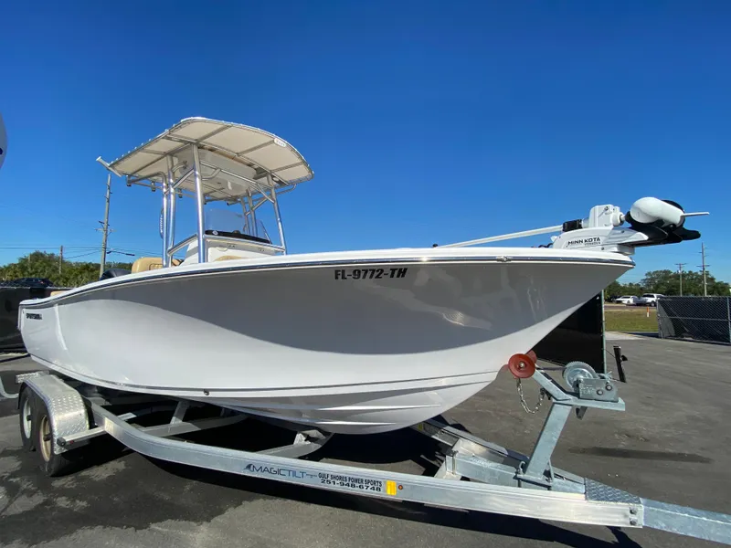 The Image of 2021 Sportsman Heritage 211 Center Console boat on trailer, clear blue sky background. - 0