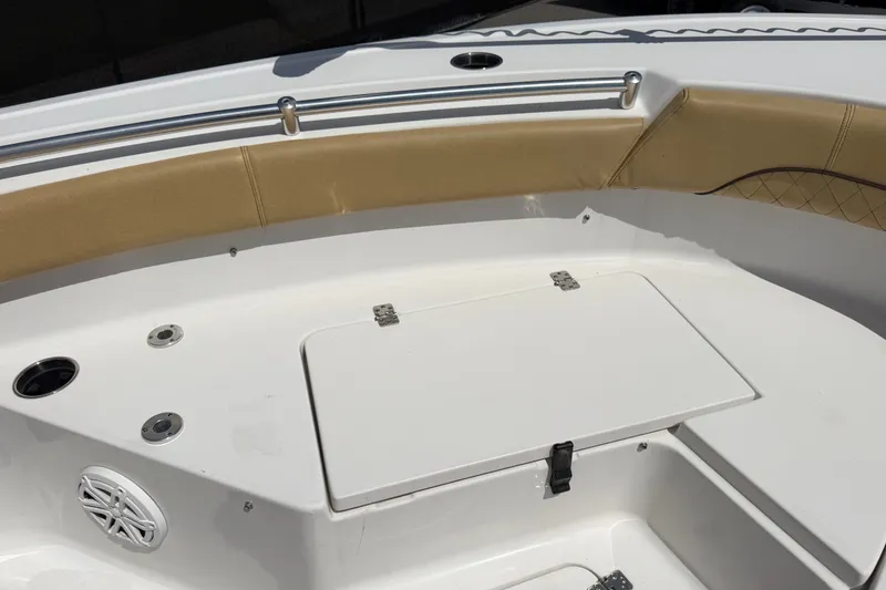 Slide: The Image of 2021 Sportsman Heritage 211 Center Console boat interior with tan seating and storage compartment. - 41