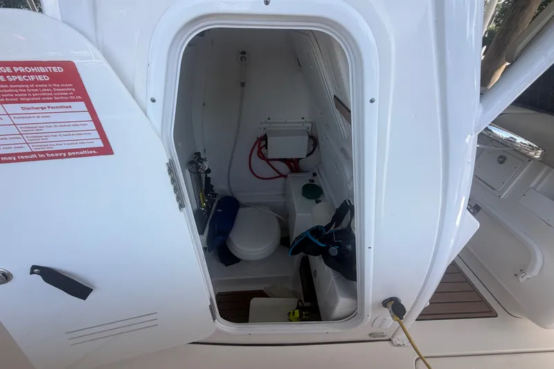 Slide: The Image of 2021 Tidewater 272 CC Adventure boat interior with open door showing storage and equipment. - 21