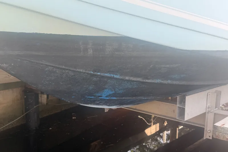 Slide: The Image of 2021 Tidewater 272 CC Adventure boat hull on lift, showing wear and marine growth. - 47