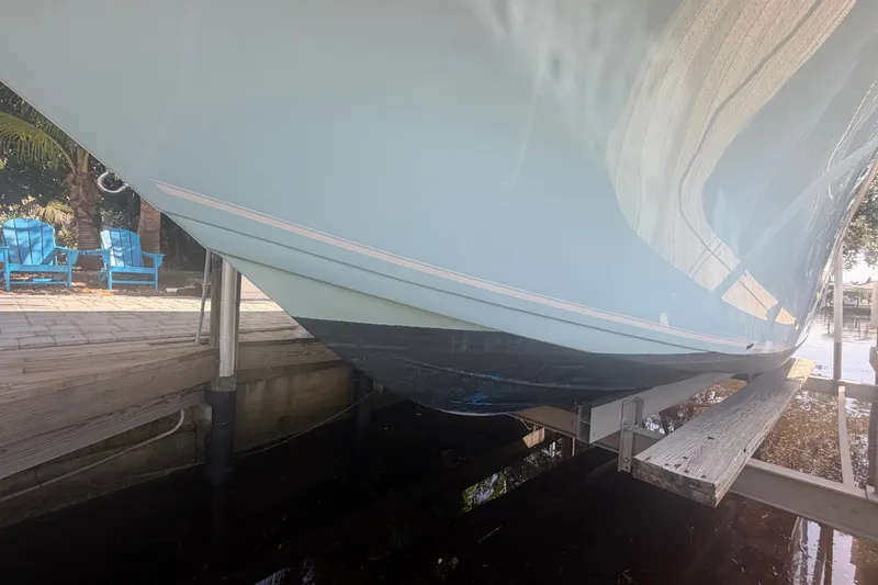 Slide: The Image of 2021 Tidewater 272 CC Adventure boat on lift, dockside view. - 48