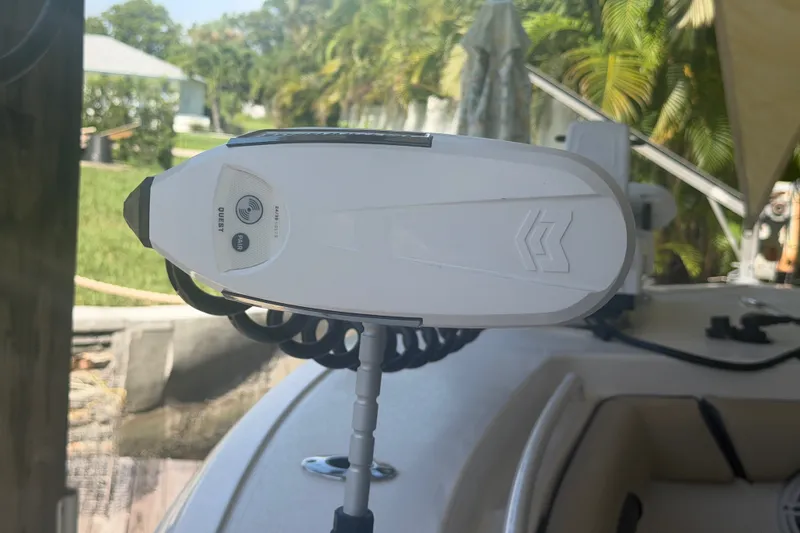 Slide: The Image of Trolling motor on 2021 Tidewater 272 CC Adventure boat, surrounded by lush greenery. - 29
