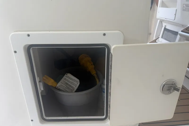 Slide: The Image of Storage compartment on a 2021 Tidewater 272 CC Adventure boat with electrical cables inside. - 42