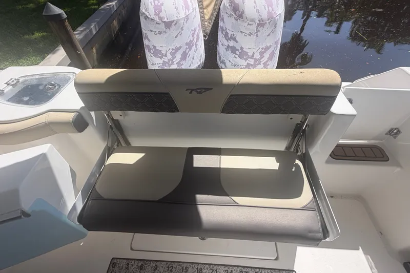 Slide: The Image of 2021 Tidewater 272 CC Adventure boat seat with storage, featuring beige and black upholstery. - 36