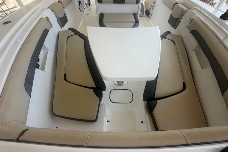 Slide: The Image of 2021 Tidewater 272 CC Adventure boat interior with cushioned seating and table. - 24