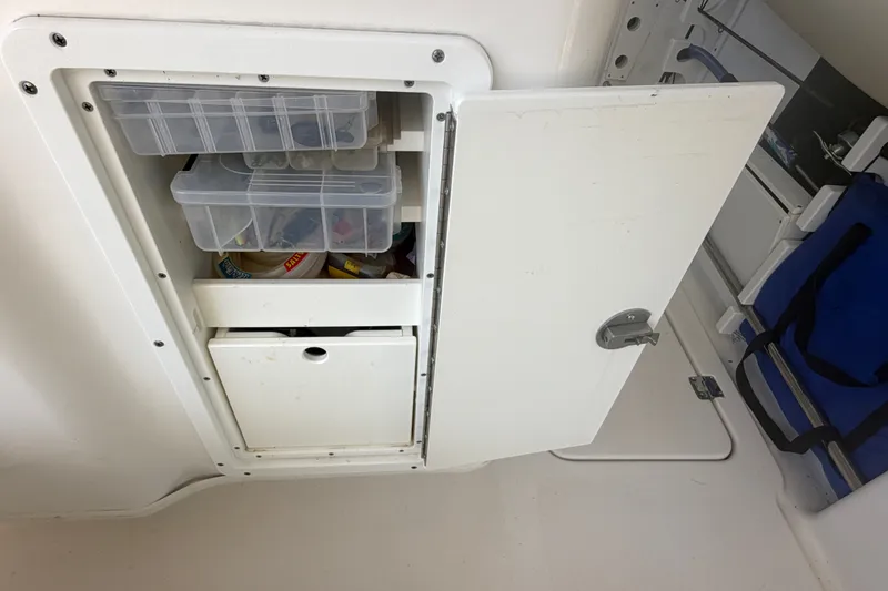 Slide: The Image of Storage compartment on 2021 Tidewater 272 CC Adventure boat with organized tackle boxes. - 41