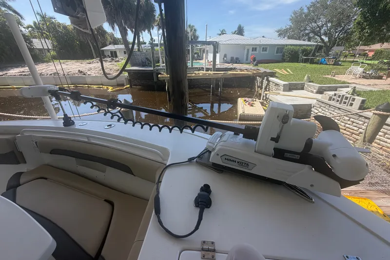 Slide: The Image of 2021 Tidewater 272 CC Adventure boat with Minn Kota trolling motor docked by a waterfront property. - 28