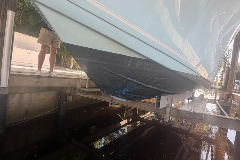 Slide: The Image of 2021 Tidewater 272 CC Adventure boat on lift, showing hull and dock. - 49