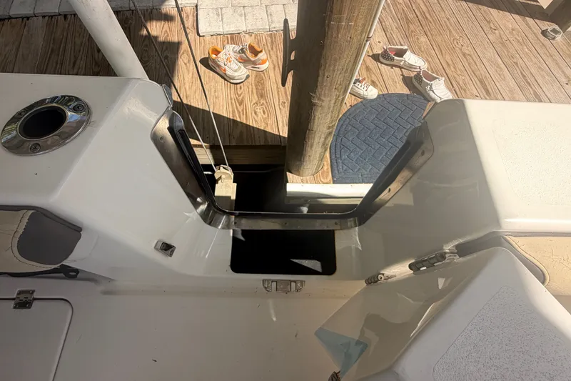 Slide: The Image of 2021 Tidewater 272 CC Adventure boat interior with dock view and shoes on deck. - 38