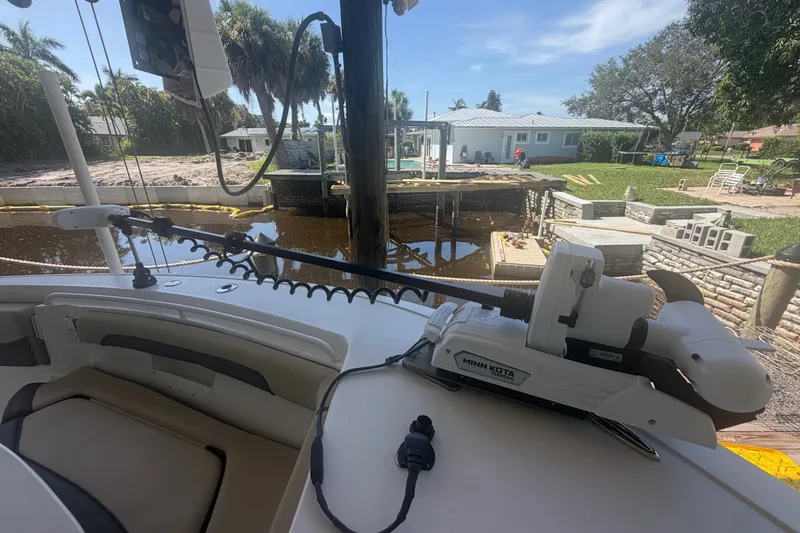 Slide: The Image of 2021 Tidewater 272 CC Adventure boat with Minn Kota trolling motor docked by a waterfront home. - 27