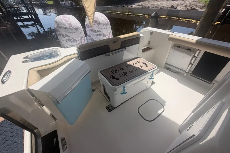 Slide: The Image of 2021 Tidewater 272 CC Adventure boat interior with seating and cooler on deck. - 13