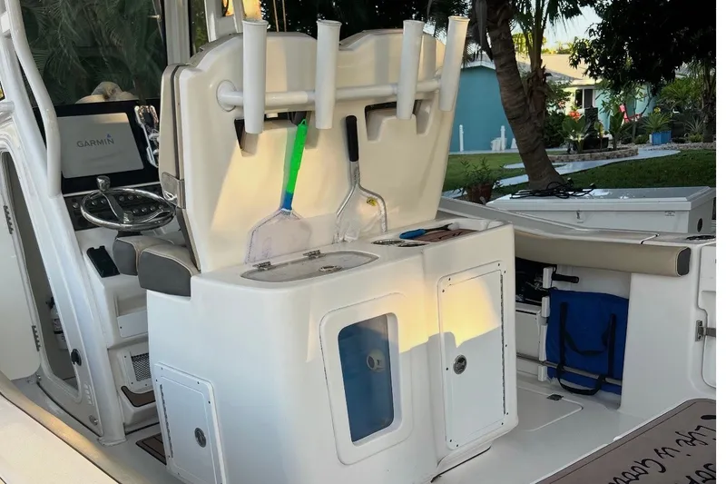 Slide: The Image of 2021 Tidewater 272 CC Adventure boat interior with fishing rod holders and Garmin equipment. - 11