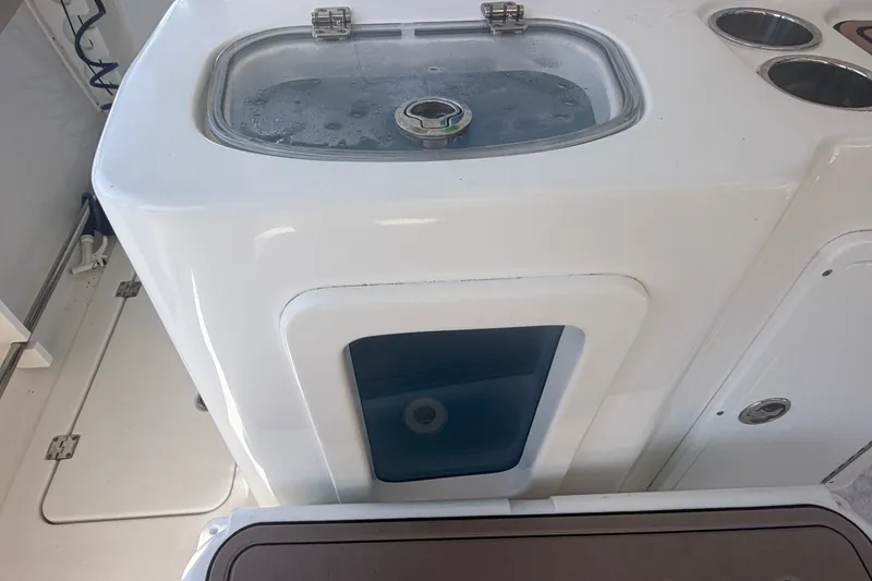 Slide: The Image of Livewell on 2021 Tidewater 272 CC Adventure boat, featuring a clear lid and cup holders. - 39
