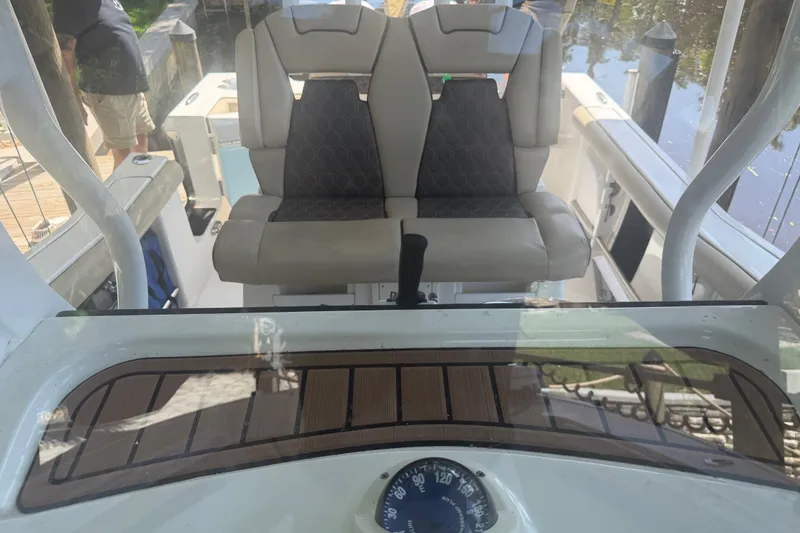 Slide: The Image of 2021 Tidewater 272 CC Adventure boat interior with dual seats and dashboard view. - 33