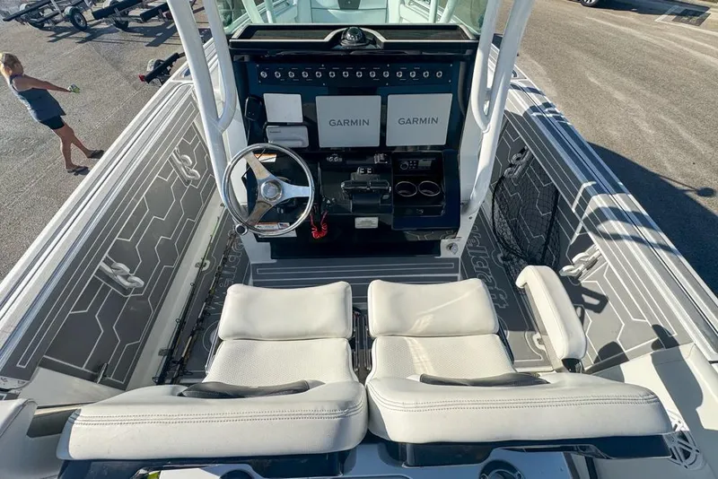 Slide: The Image of 2021 Wellcraft 262 Fisherman boat cockpit with dual Garmin displays and white seating. - 47