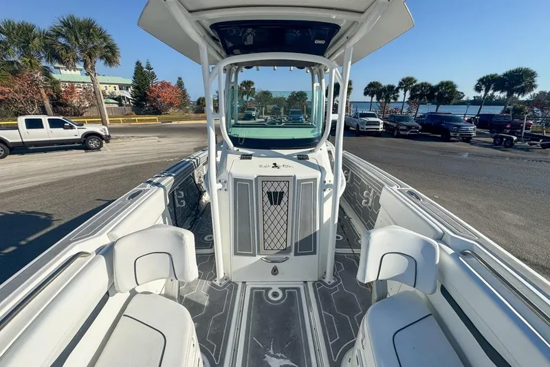 Slide: The Image of 2021 Wellcraft 262 Fisherman boat interior with seating and console, parked near palm trees. - 69