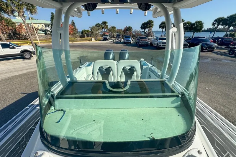 Slide: The Image of 2021 Wellcraft 262 Fisherman boat with clear windshield and seating, parked near waterfront. - 80