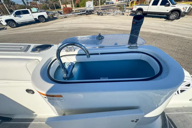 Slide: The Image of 2021 Wellcraft 262 Fisherman boat with livewell and faucet, parked near trucks. - 33