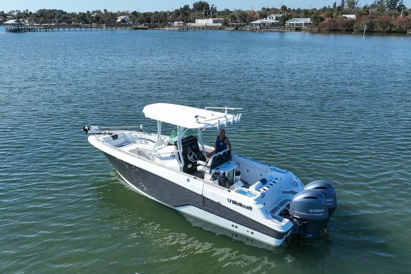 Slide: The Image of 2021 Wellcraft 262 Fisherman boat on calm water, featuring dual Yamaha engines. - 21