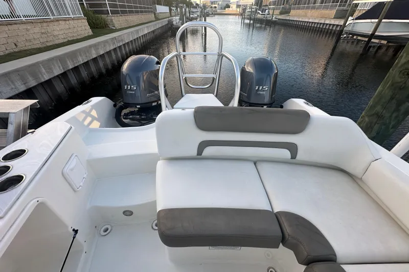 Slide: The Image of 2021 World Cat 230 SD boat interior with dual Yamaha 115 engines, docked in a canal. - 68