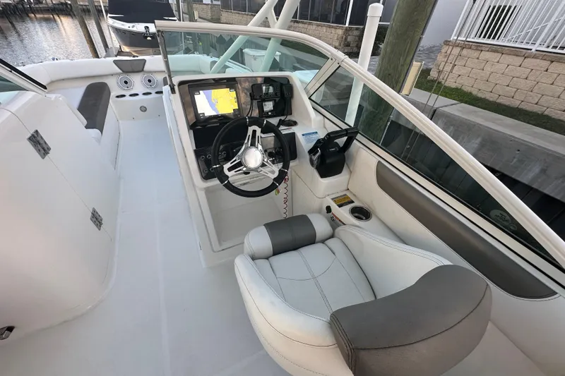 Slide: The Image of 2021 World Cat 230 SD boat interior with steering wheel and navigation system. - 18